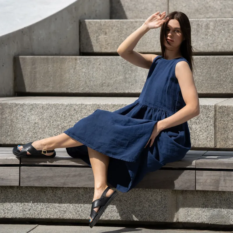 Young woman posing in a city, wearing linen smock dress Maya in a Storm blue cover.