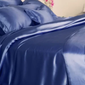 Kumi Kookoon Classic Silk pillowcase in sapphire silk on a made bed.