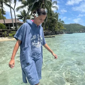 Poncho surf adulte ALL-IN Island porté en bord de mer tropical, coloris bleu indigo