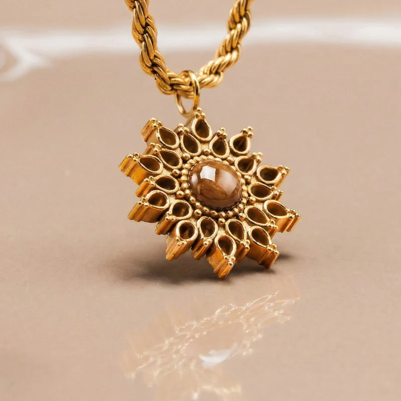 Halskette mit goldfarbener Gliederkette und Anhänger in Sonnenform mit braunem Stein